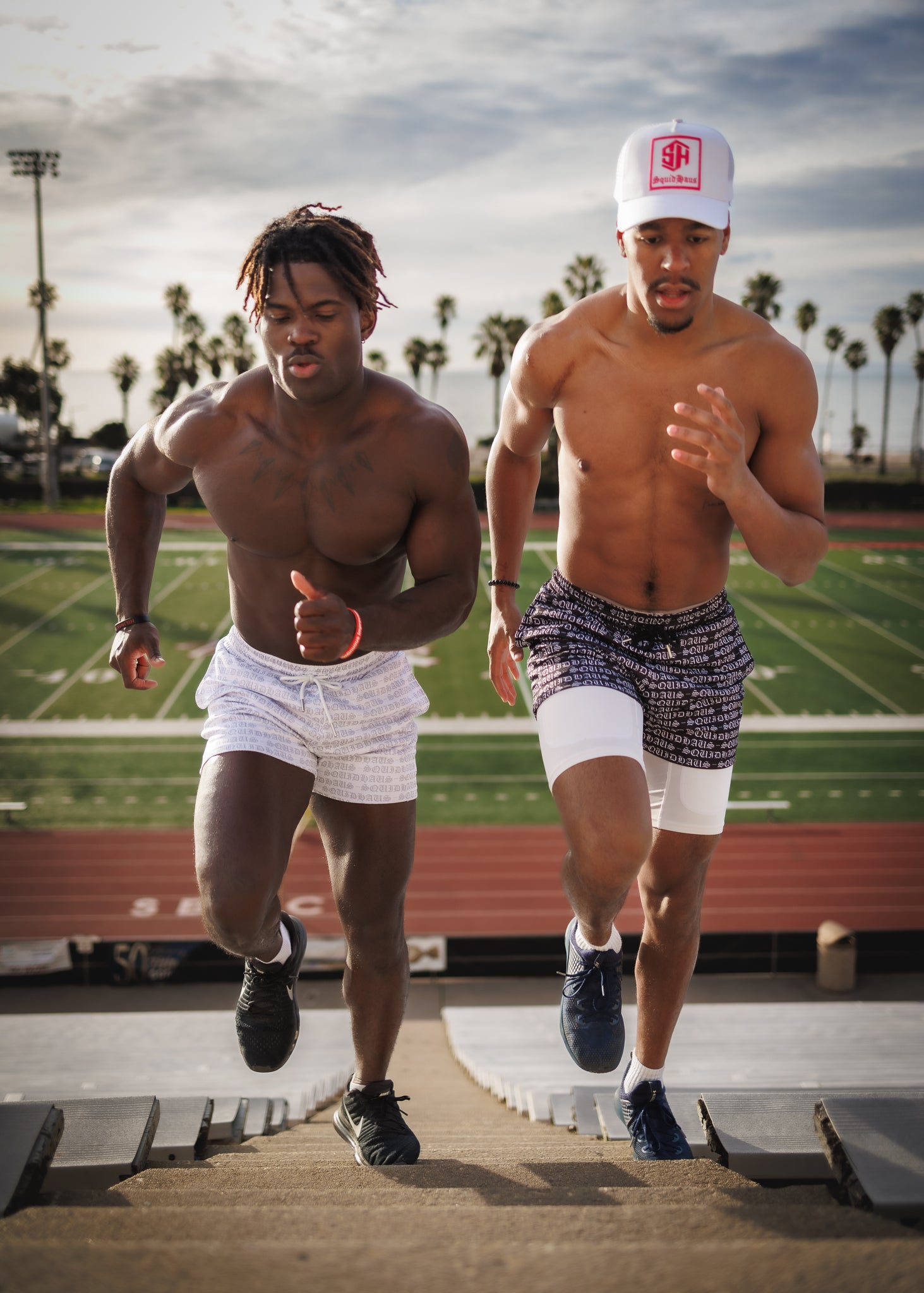 Two athletes running up the stairs at a football stadium, wearing men's mesh shorts with 4" inseams from SquidHaus